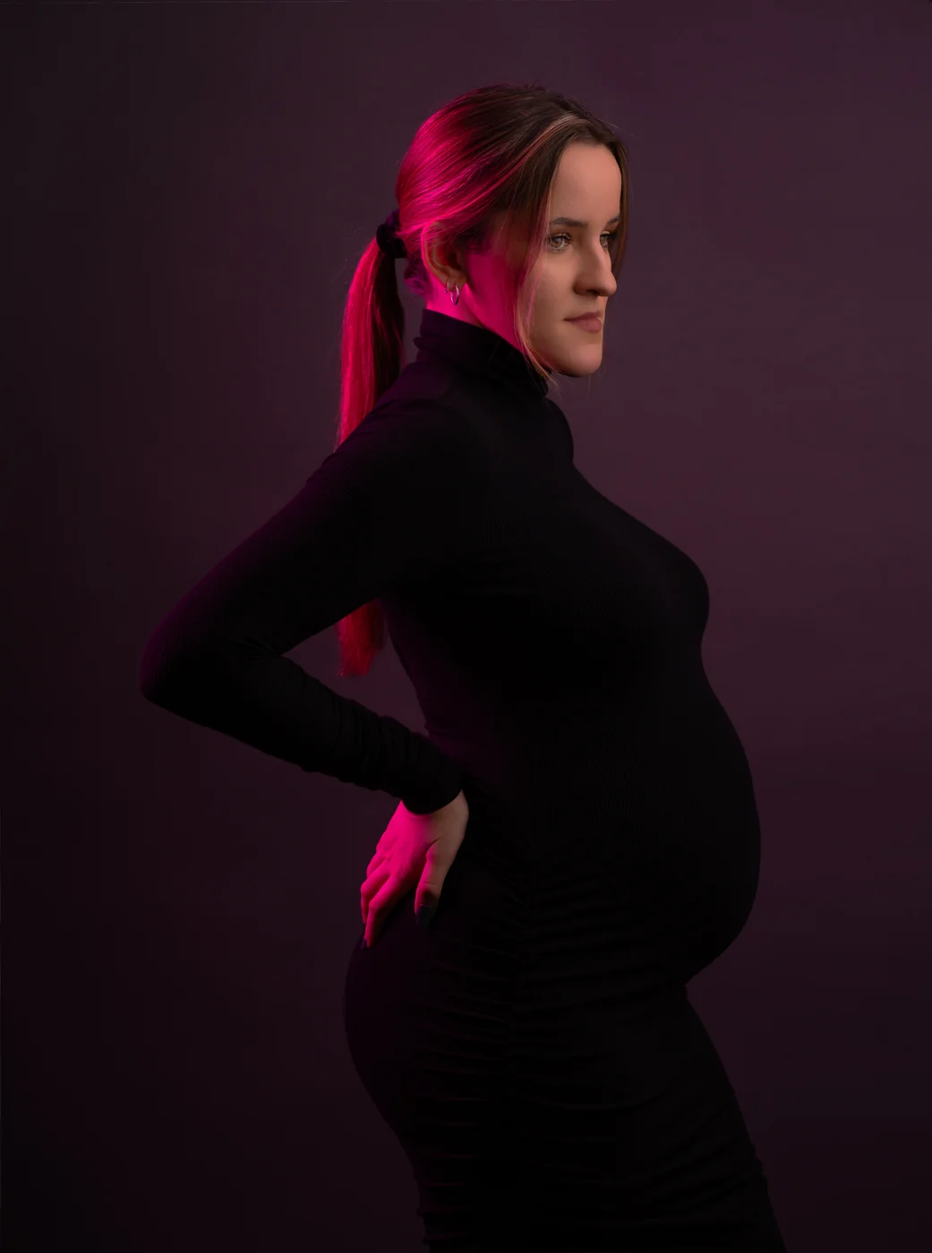 Mariola in profile, maternity portrait lit in magenta