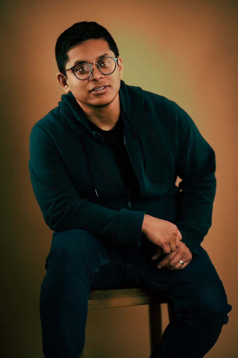 Luis — studio portrait against a warm amber backdrop